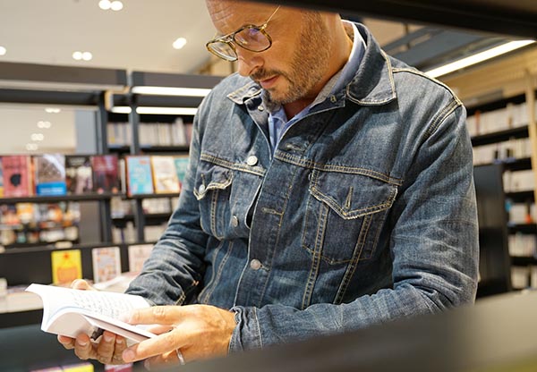 Man in bookstore looking at books